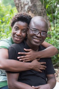 young couple embracing on vacation sitting in nature.