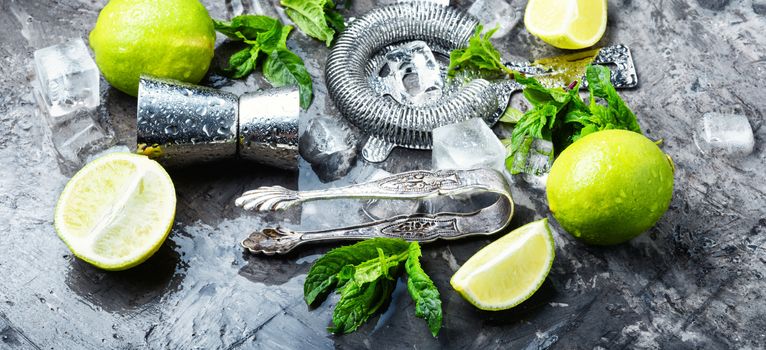 Mint, lime, ice ingredients and bar utensils