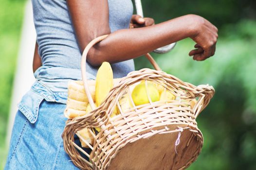 Young woman carrying a basket full of provisions.
