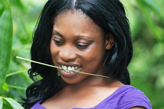 this young woman in the bush playing with the leaves of shrubs.