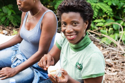 this smiling young woman is cutting an orange.