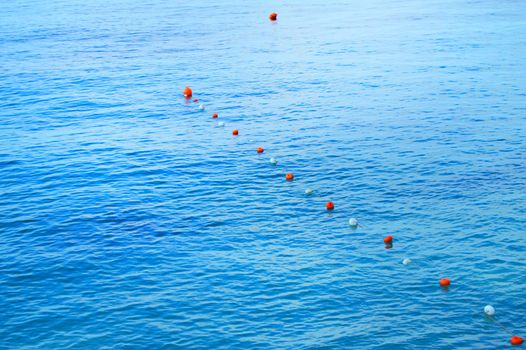 Separation buoys in the sea for safe swimming on the beach.