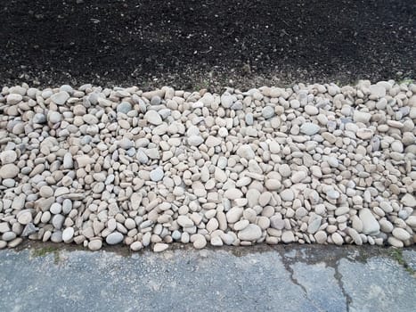 white and grey stones or rocks with brown dirt or soil and asphalt