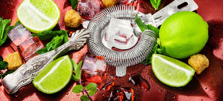 Mint, lime, ice ingredients and bar utensils.Strong alcoholic drinks