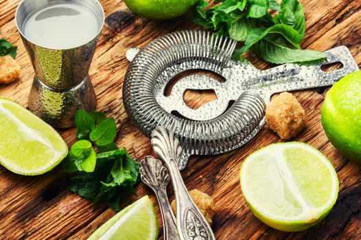 Mint, lime, ice ingredients and bar utensils.Strong alcoholic drinks