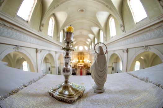 Statue of Virgin Mary and candle in candlestick. Riga St. Albert Roman Catholic congregation, Roman Catholic Church in Riga, Latvia. Interior of the Roman Catholic Church. 