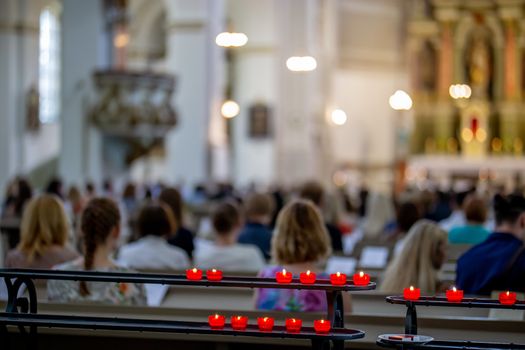 Wedding marriage ceremony in church. Burning candles in the church during the wedding ceremony. Christian church decorated from candles for wedding marriage ceremony. 