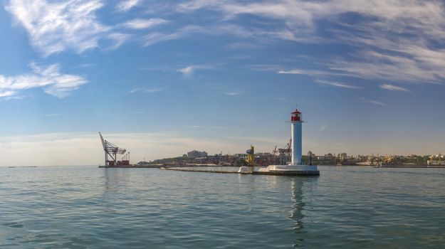 Lighthouse at the entrance to the harbor of the Odessa port, the sea gates of Ukraine in a sunny summer day