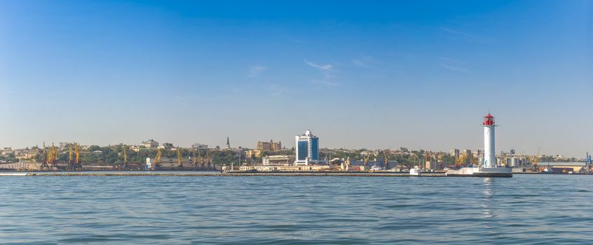 Lighthouse at the entrance to the harbor of the Odessa port, the sea gates of Ukraine in a sunny summer day