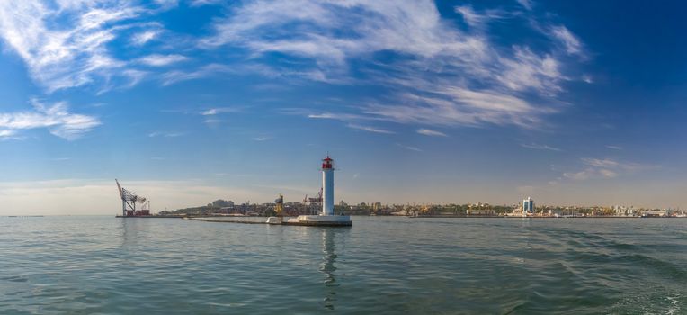 Lighthouse at the entrance to the harbor of the Odessa port, the sea gates of Ukraine in a sunny summer day