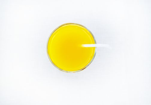 Summer drink - freshly squeezed orange juice in a glass with straw tube, top view, isolated on white background, minimalism style.