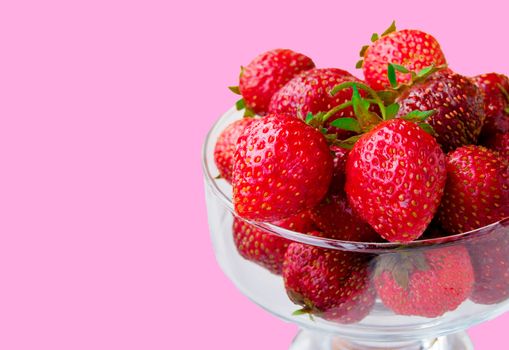 Glass bowl with fresh ripe strawberries, space for text, copy space isolated on pink background, layout, clipping.