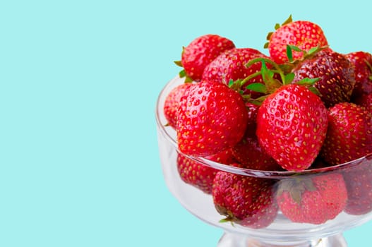Glass bowl with fresh ripe strawberries, space for text, copy space isolated on blue background, layout, clipping.