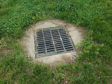 metal grate with cement and green grass or lawn outdoor