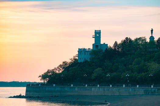 Sunset on the embankment of the Amur river in Khabarovsk. The sun set over the horizon. The embankment is lit by lanterns.