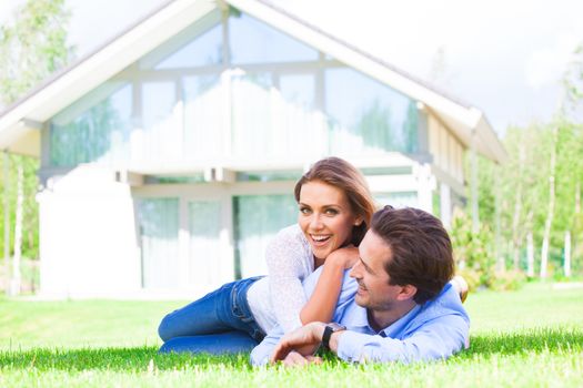 Happy smiling couple laying down in their home garden