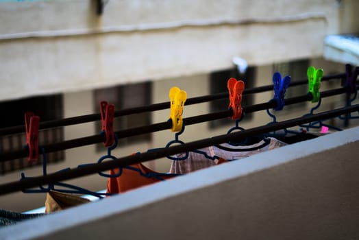colored clothespin holding hanging clothes in a high-rise housing block courtyard