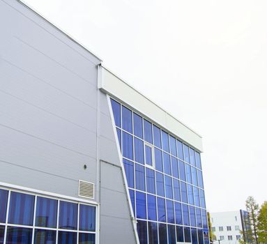 Modern office building with glass wall, nearby Parking.