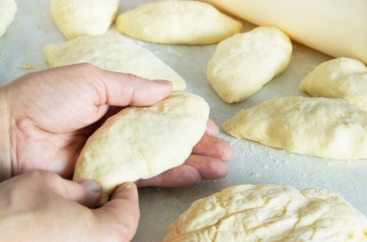 Female hands making biscuits and pie dough, close-up.