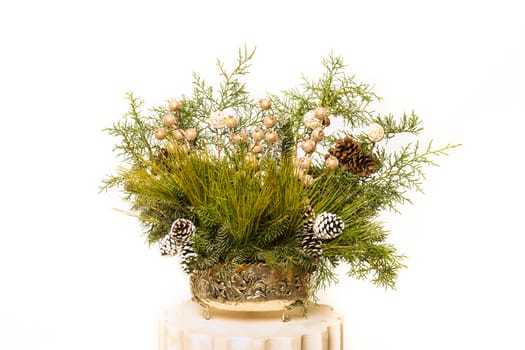 Christmas festive decoration with red baubles, holly with red berries , snow covered pine cones and winter greenery over woodpanel background.