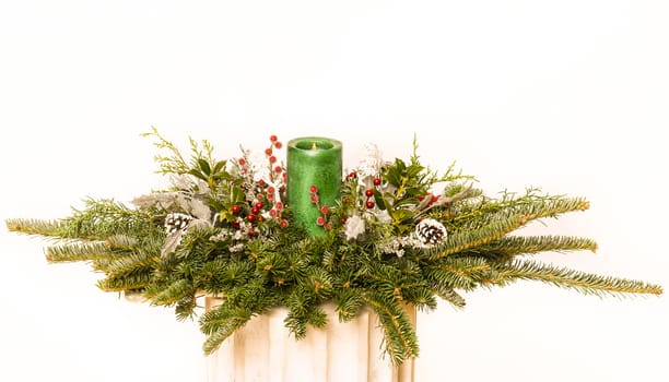 Christmas festive decoration with red baubles, holly with red berries , snow covered pine cones and winter greenery over woodpanel background.