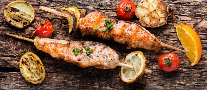 Grilled salmon with vegetables on wooden table.Grilled fish with lemon