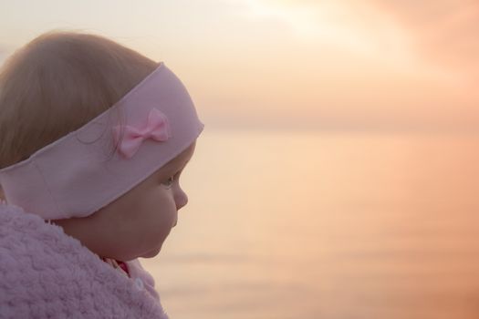infant looking for the first time on the sea - sunset. beautiful orange landscape