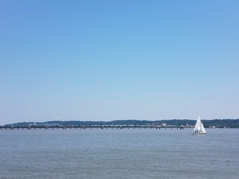 Potomac river water with sailboat and pier and Washington, DC in the background