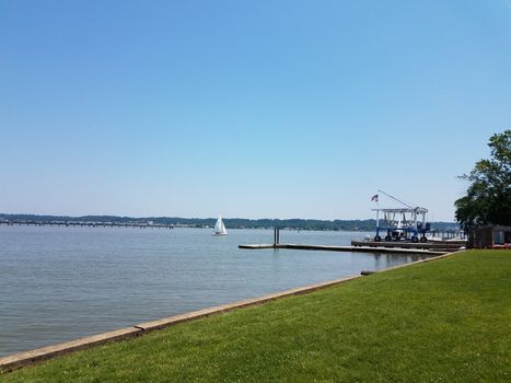 Potomac river with sailboat and pier and Washington, DC with boat lift or crane