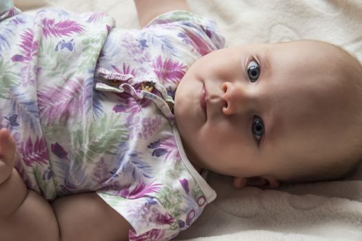 happy newborn, baby with big eyes smiling looking at the camera close-up portrait photo. Beautiful picture, background, wallpaper 
