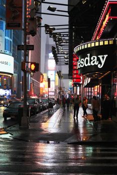 New York, USA - May 20, 2013: taxi's crossing at Time Square at night in the rain. The site is regarded as the world's most visited tourist attraction with nearly 40 million visitors annually.