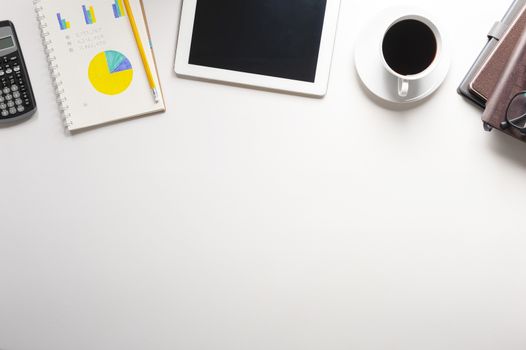 Top view of tablet, notebook, a cup of coffee on white background, planning personal budget, business and financial concept.