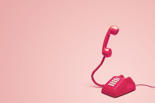 Retro pink telephone on retro pink background, Pop art or vintage style
