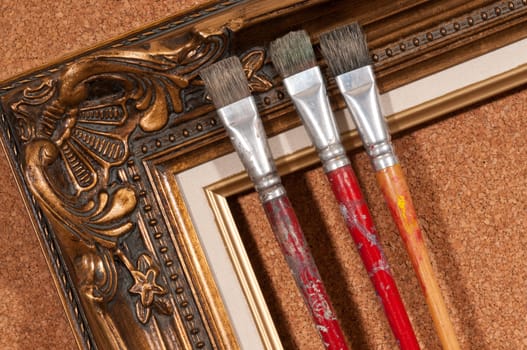 Paint brushes and wood picture frame.