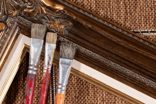 Paint brushes and wood picture frame.