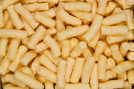 Corn puffs snack food texture background, close up detail.