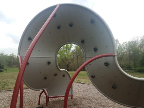 curved playground climbing structure wall with hand and foot holds at park