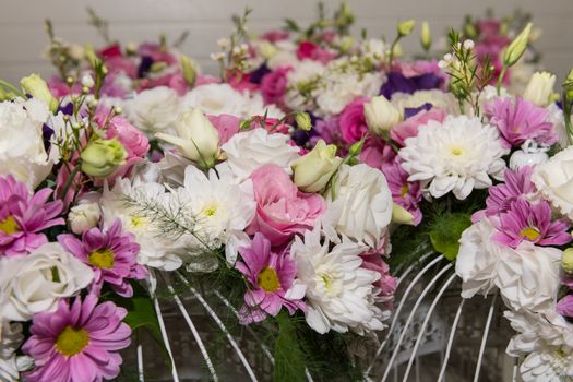 Various bridal flower heads in vintage ornate bird cage as bloom decoration at a wedding reception.