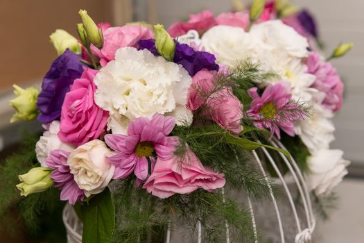 Various bridal flower heads in vintage ornate bird cage as bloom decoration at a wedding reception.