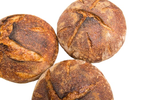 Fresh baked loafs of round artisan sourdough bread isolated on a white background.