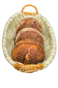 Fresh baked loafs of round artisan sour dough bread in a bread basket.