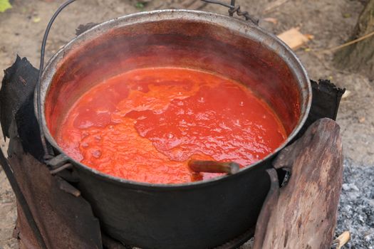 Making tomato sauce the old fashioned way in a large pot.