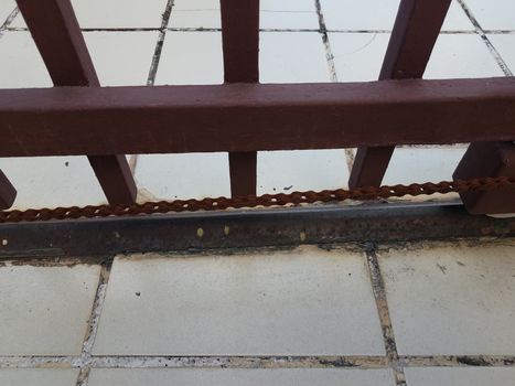 rusty metal door or gate with chain and tiled floor