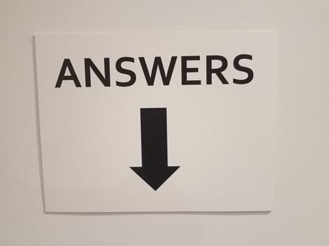 white and black answers sign with down arrow or pointer