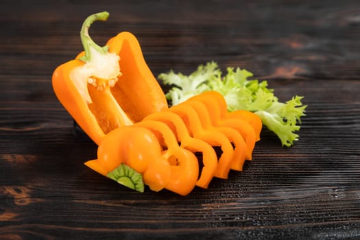 Paprika of orange color cutting on a wooden chopping board