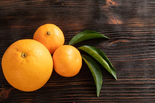 top view of whole ripe tangerines scattered on wooden chopping board