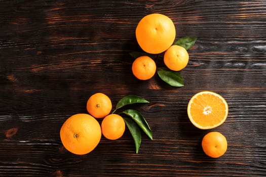 top view of whole ripe tangerines scattered on wooden chopping board