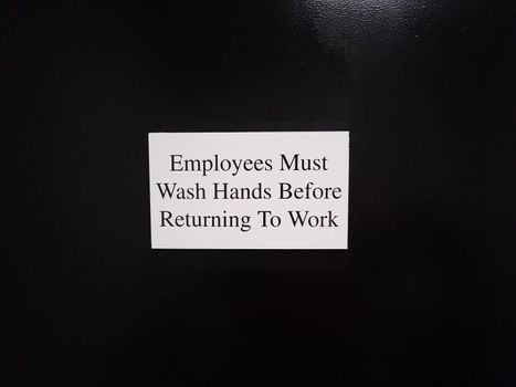 employees must wash hands before returning to work on black wall or surface