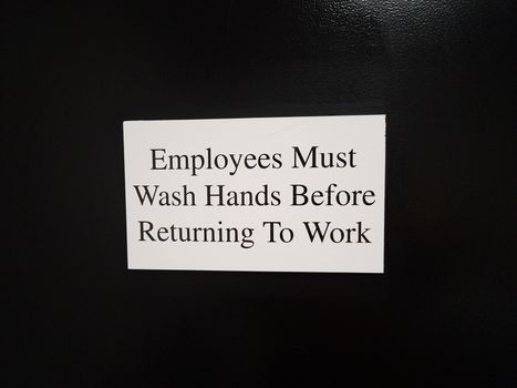 employees must wash hands before returning to work on black wall or surface