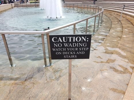 caution no wading watch your step on decks and stairs sign and fountain with railing